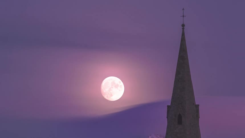 Time lapse of full moon going up behind the church spire