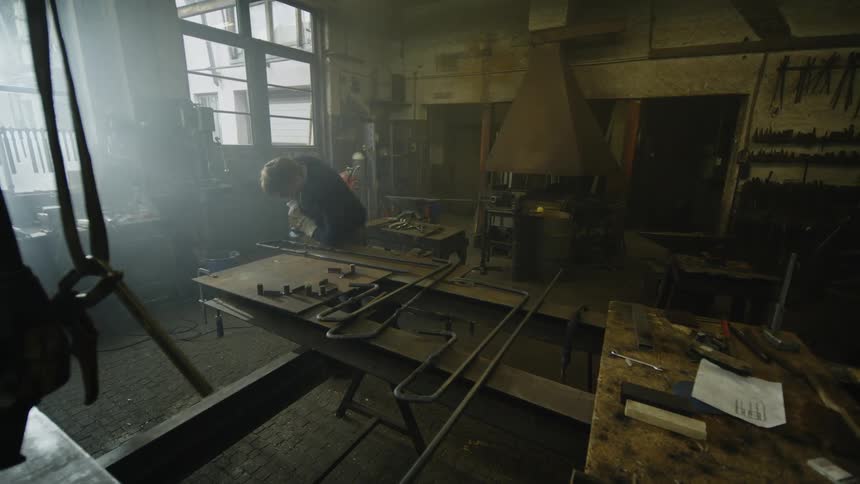 A blacksmith is working in his shop