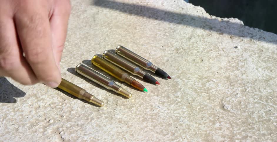 A hand looks through bullets lifting one
