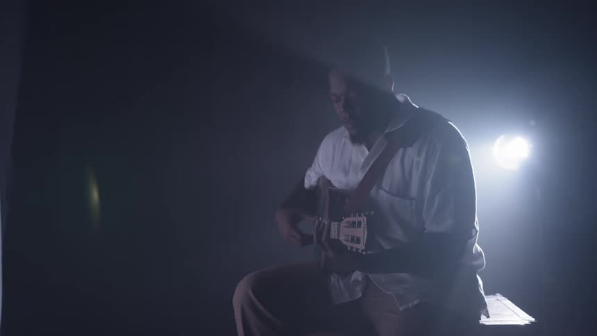 A man playing guitar and singing