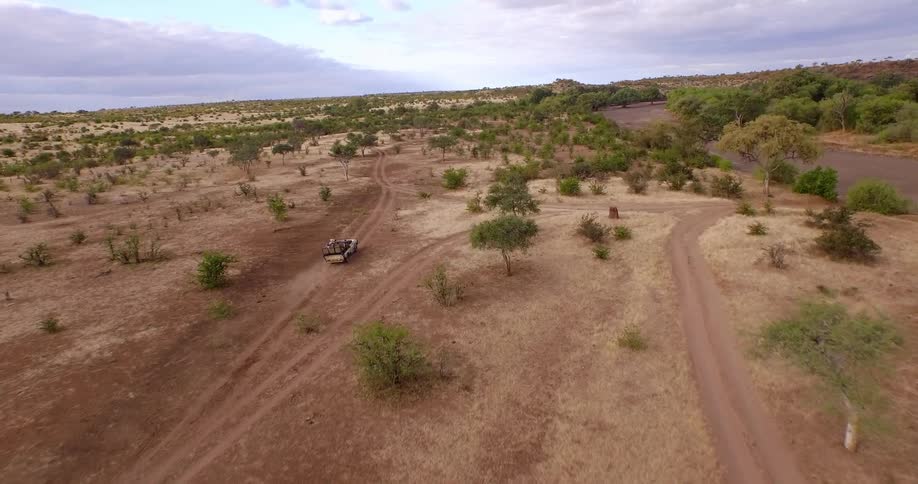 A vehicle is racing across the dirt field below