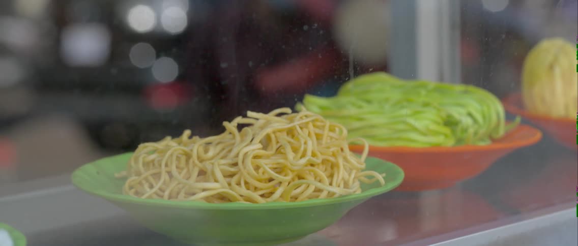 Food sits in bowls on a glass shelf