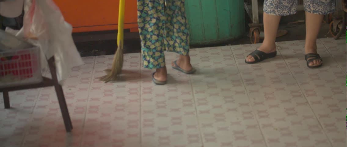 Person sweeping a floor with a broom