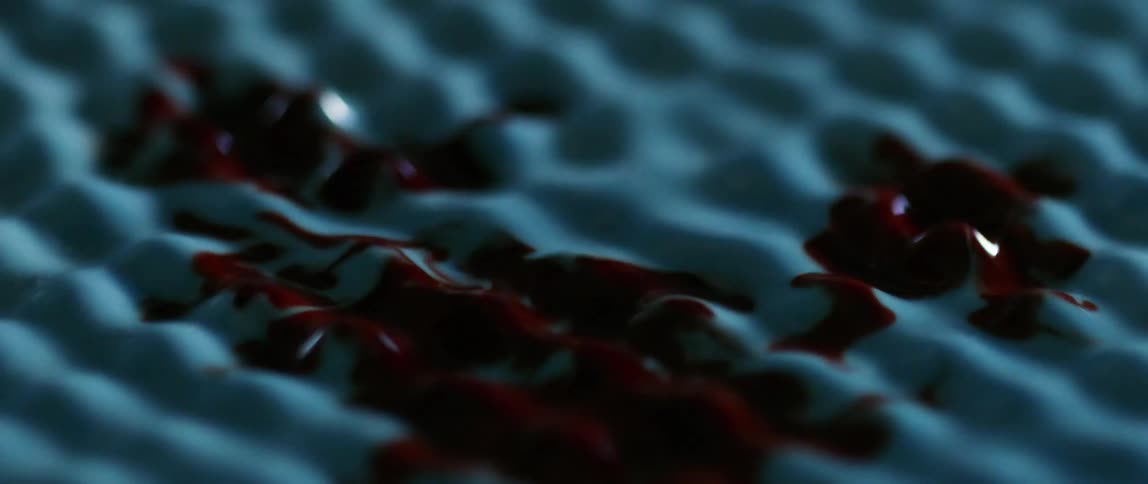 Red liquid drops onto shaking blue liquid