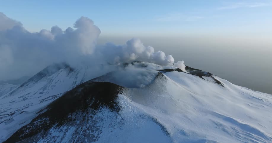 Aerial view of volcanic snowcovered mountain like mount fuji with steam coming out
