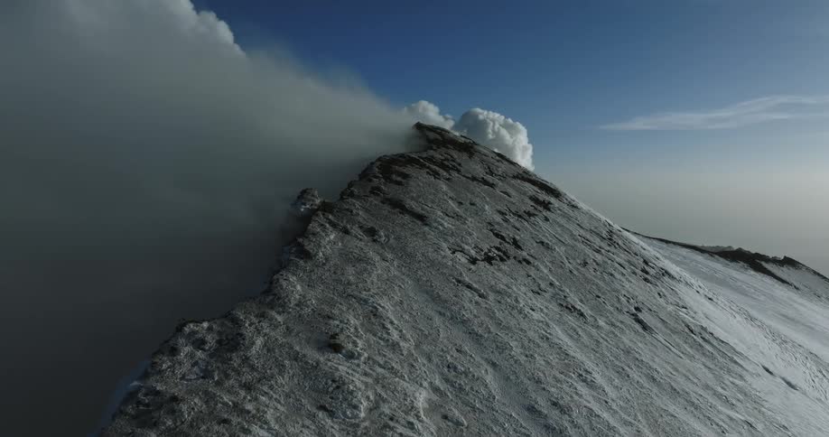 Dense clouds move over a mountain peak