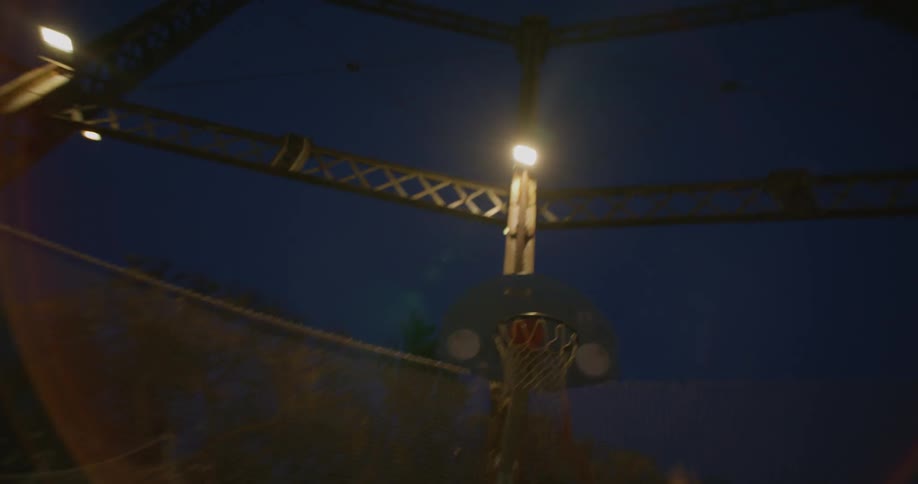 A basketball player makes a basket in a casual nighttime game
