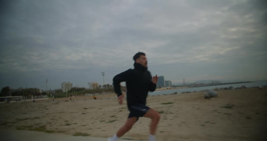 A man is jogging outdoors at the beach