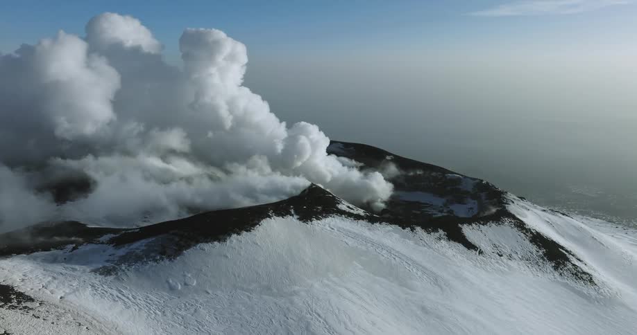 An aerial view of a snowy mountain landscape in winter