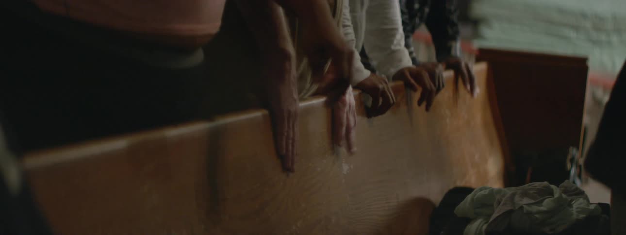 People watching an activity while leaning on a board