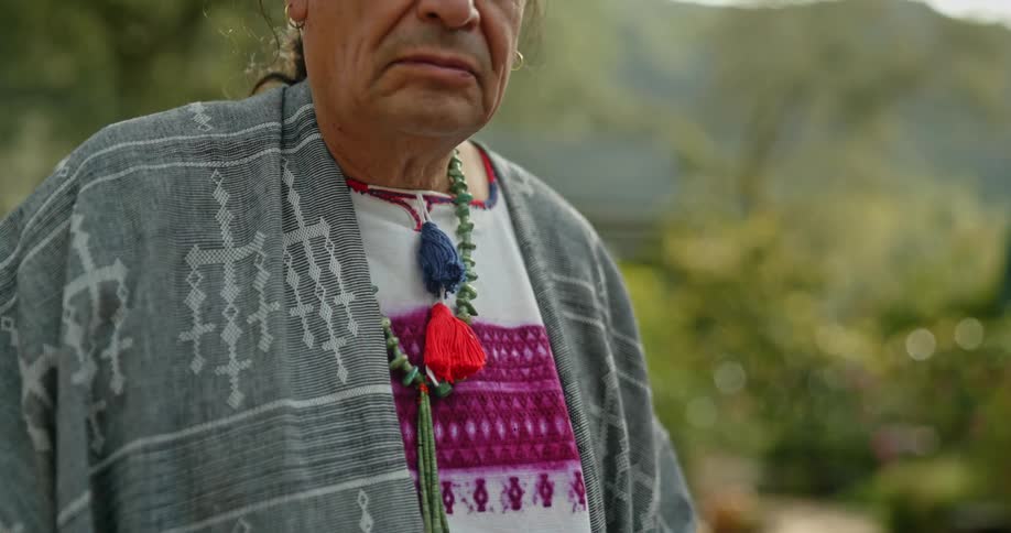 A native american man stands outside
