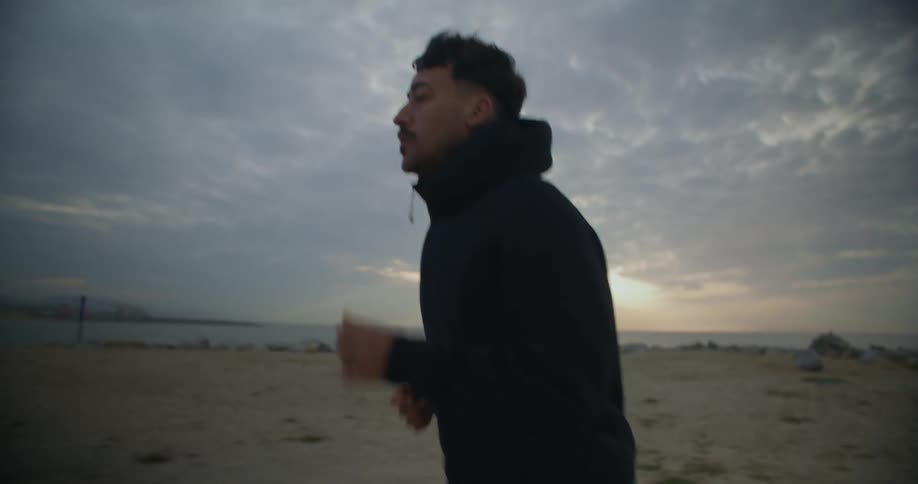 A man is jogging on the beach