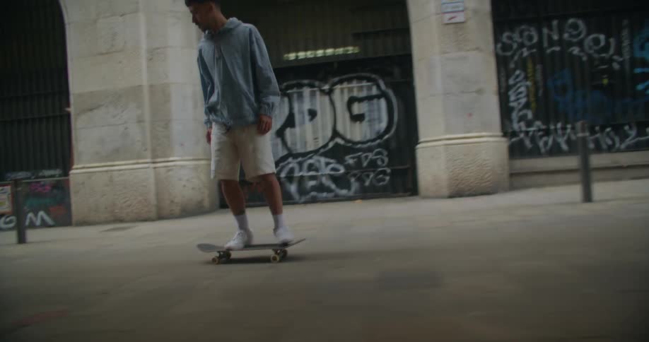 Tracking shot of a young man failing to land on his skateboard in the city street