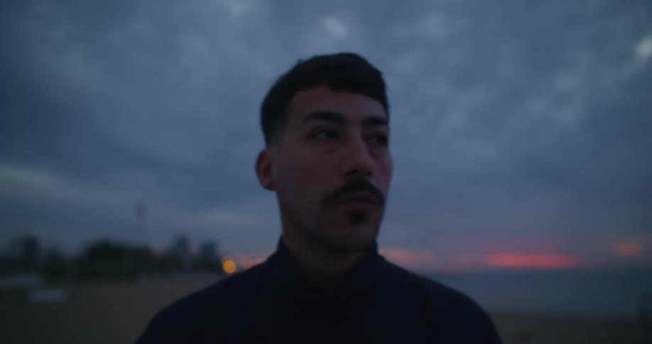 A man is walking at the beach during dusk