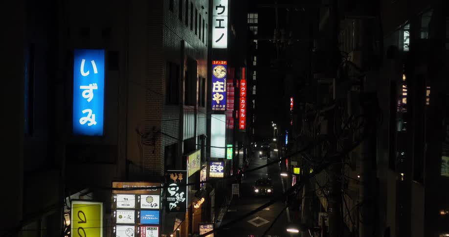 Cars driving on narrow street at night