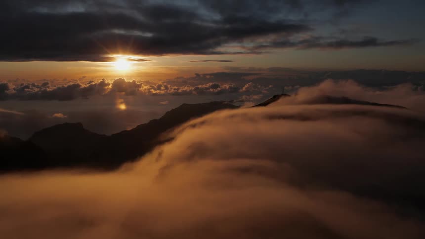 The sun is setting behind the mountains