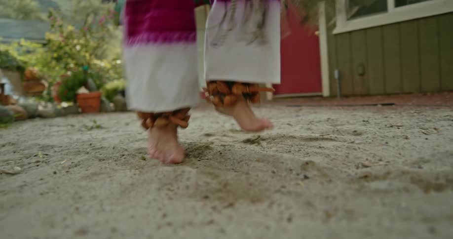 A close up of a persons feet dancing in sand