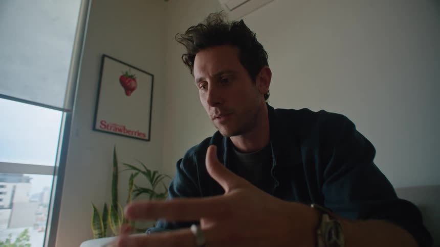 A man is talking to someone and sitting indoors