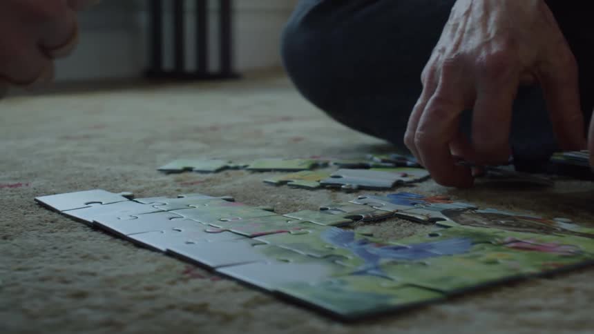 Two people are solving a puzzle together indoors