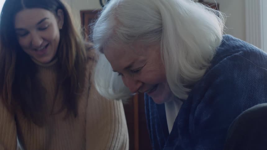 Mother and daughter are sitting indoors together