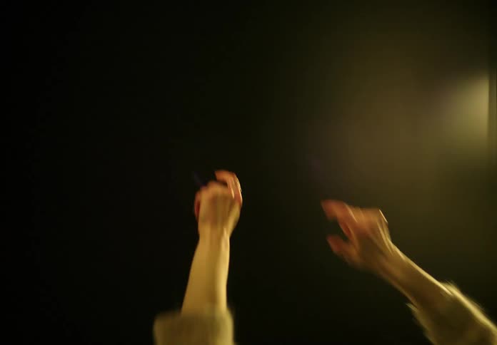 A woman is dancing outdoors at night by herself