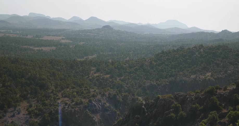 A forested valley surrounded by mountain ranges