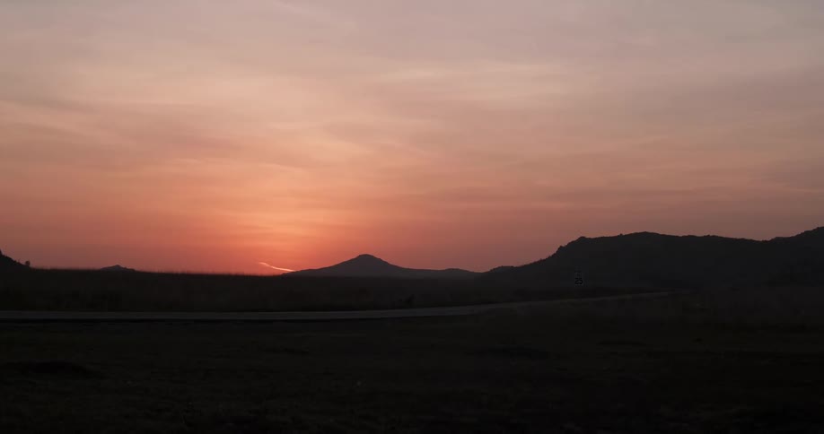 The sun sets over mountains