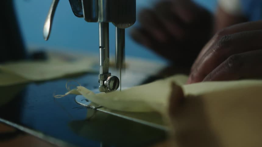 Close up of hands using sewing machine