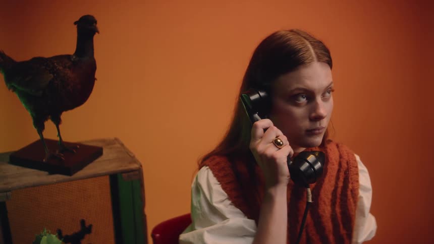 The view is of a young woman that is answering the phone