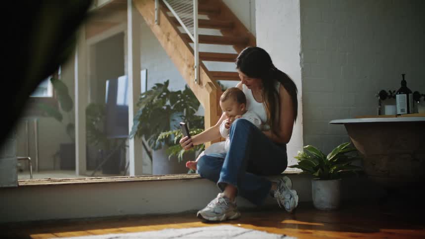 A woman is taking a selfie with her baby