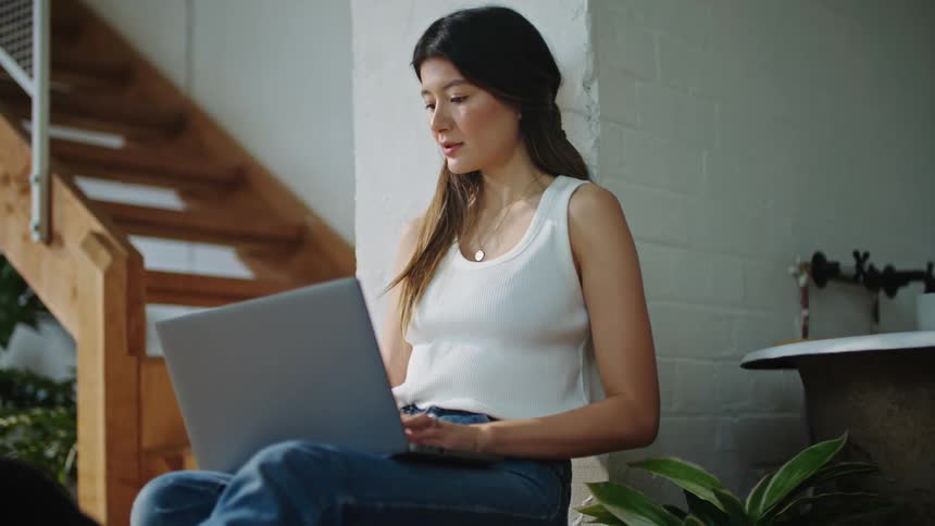 A man holding a baby across from the mother who sits with a laptop on her lap