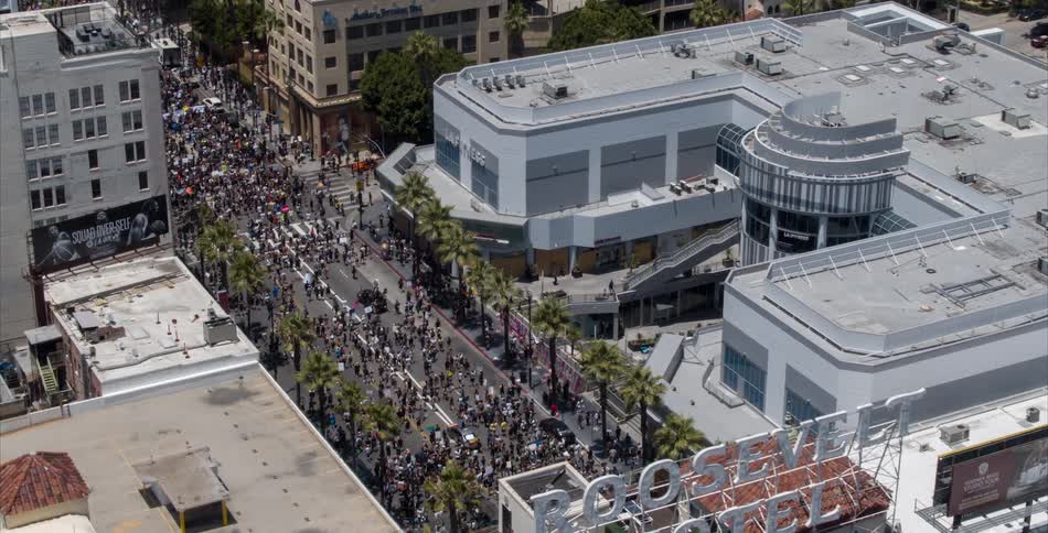 A large crowd is walking through a city during spring
