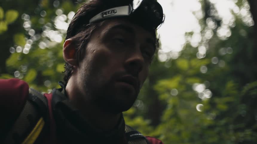 Man wearing head camera walks through woods