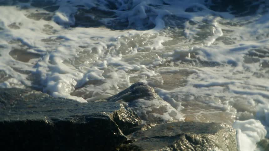 Close up view of waves crashing into rocks