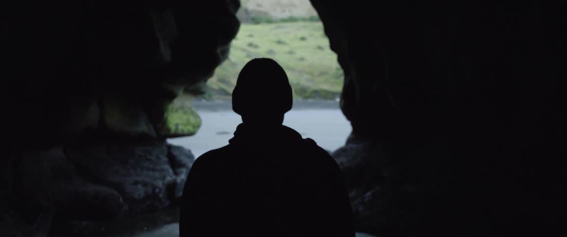 A man is walking through a cave by himself