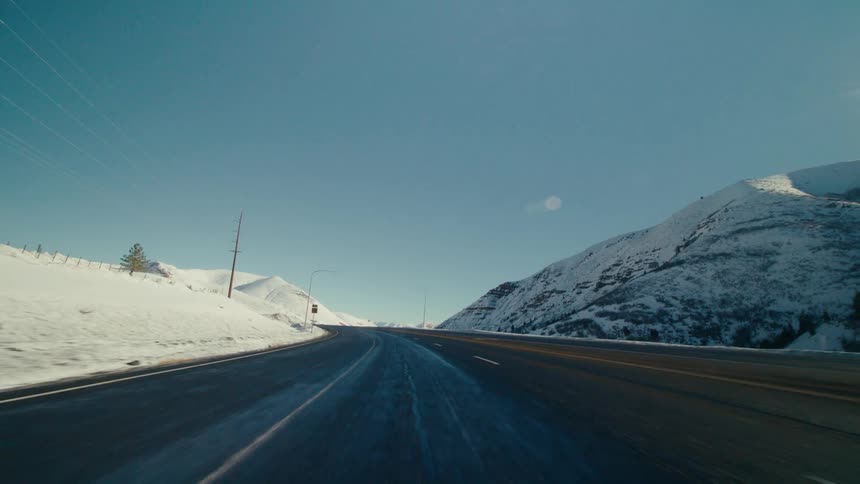 Mountains near a road in a rural area is displayed