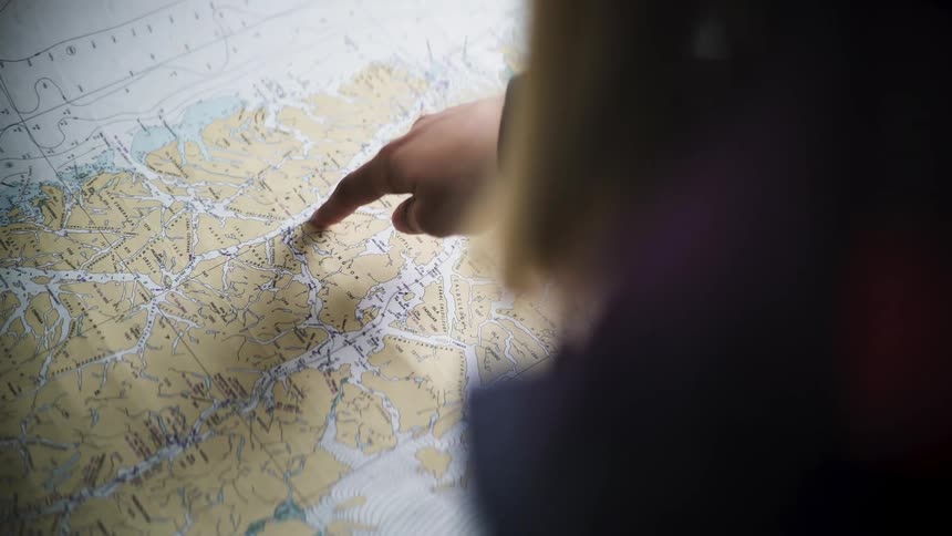Theview is of a person that is pointing at a map