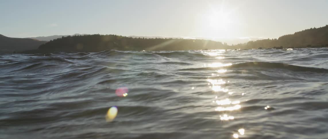 The sun is reflecting on the ocean water during dusk