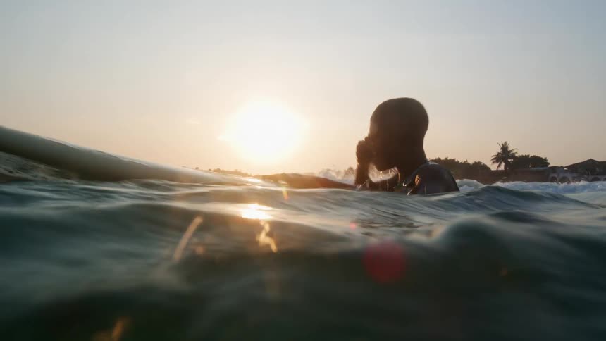 Young kid is surfing outdoors around the summer time