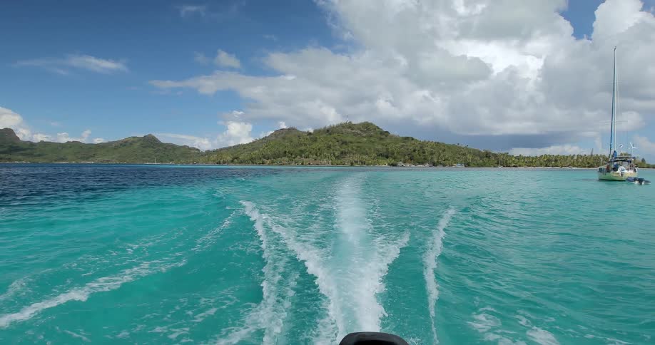 View looking off the back of a boat with water trailing behind it