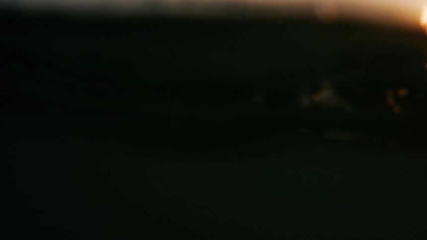 People are swimming in the ocean water at dusk