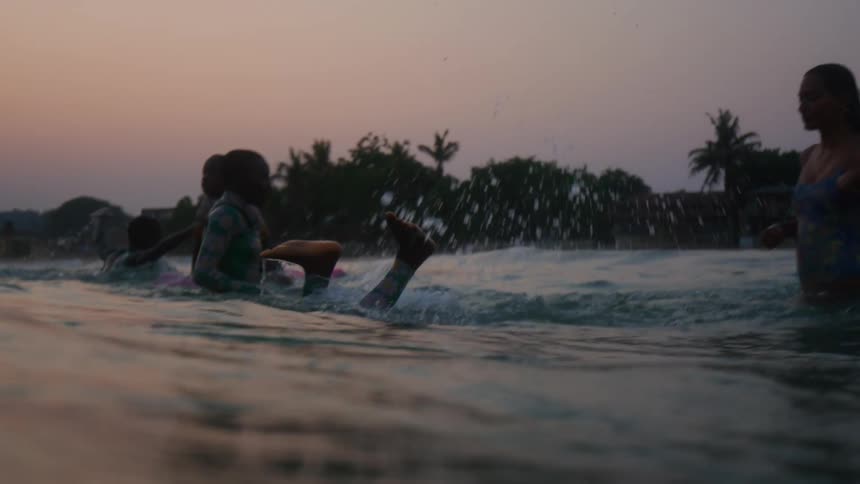 A group of children are swimming in the ocean water
