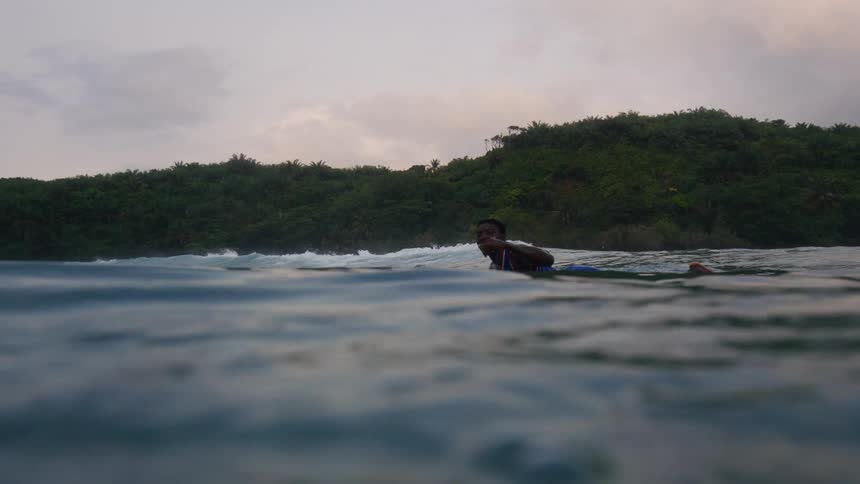 A boy is surfing in the ocean during spring time