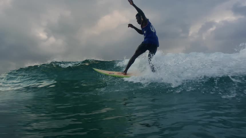 Surfer on a surfboard riding a small wave