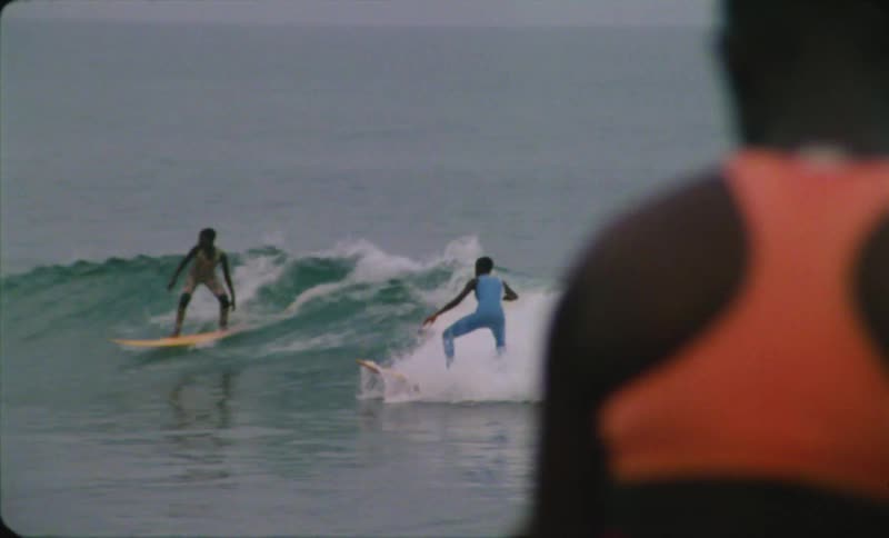 Children ride on wave on surfboards