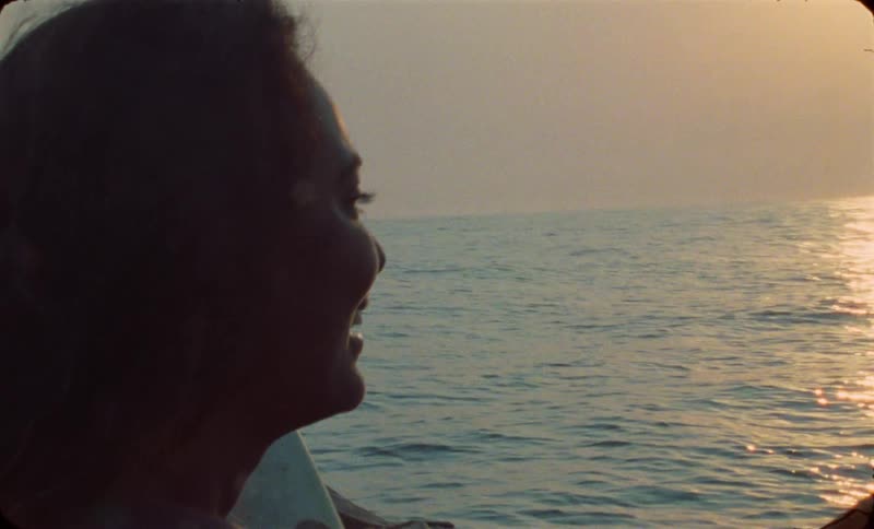 A female is riding in a boat during sunset