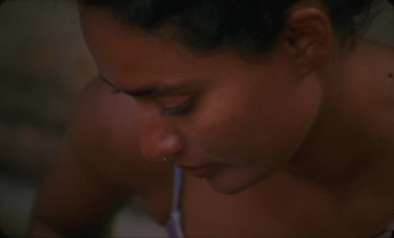 A woman is sitting outdoors at the beach