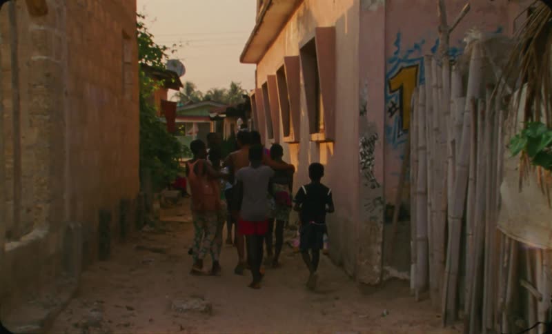 Group of friends walking on the streets of a third world country town at evening caught on vintage film