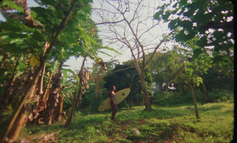 A female is walking through a tropical area