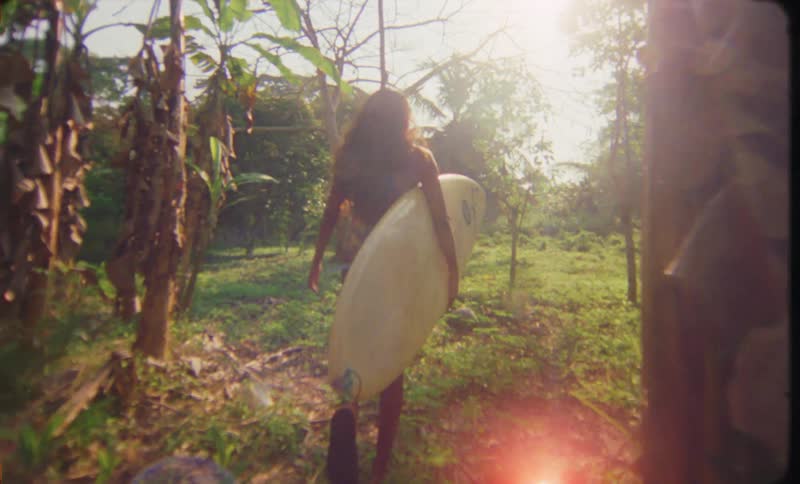 A female is walking through a tropical landscape